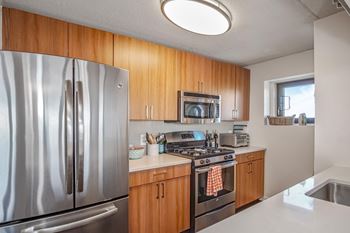 kitchen with brown cabinets, white countertops and stainless steel oven and microwave